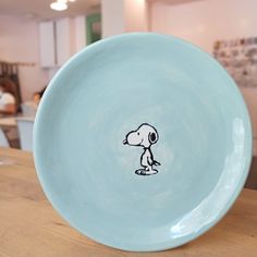 a blue bowl with a drawing of a dog on the side and people in the background