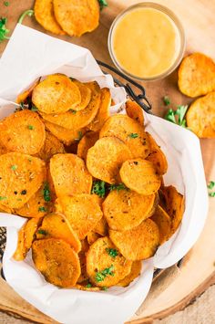 some fried food on a wooden plate with dipping sauce