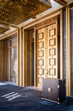 the entrance to an office building with gold and black decor on it's walls