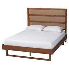 a bed with white sheets and pillows on it's headboard is made from wood