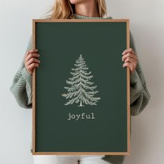 a woman holding up a green poster with the word joyful written in white on it