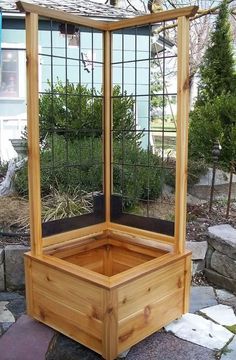 a wooden planter sitting on top of a stone walkway