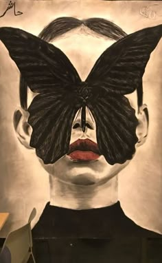 a woman's face with a black butterfly on her forehead and the image of a man's head