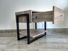 a wooden table with metal legs and drawers on the bottom, sitting on tile flooring