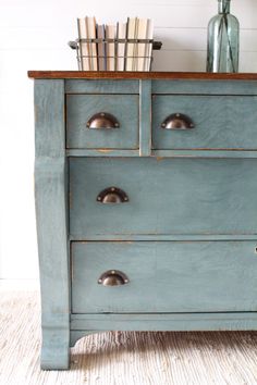 an old blue dresser with some books on top