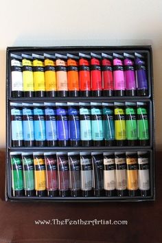 a display case filled with lots of different colors of paint on top of a wooden table