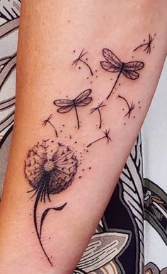 a woman's arm with a dandelion tattoo on it