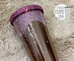 the tumbler cup has been decorated with purple and silver jewels on it's side