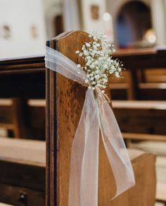 a small bouquet of baby's breath sits on the pew