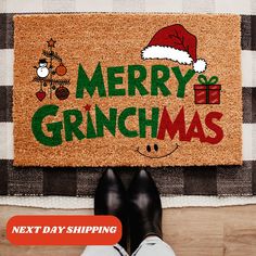 a person standing in front of a door mat with the words merry grinmas on it