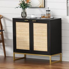 a black cabinet with wicker doors and gold trimmings in a living room