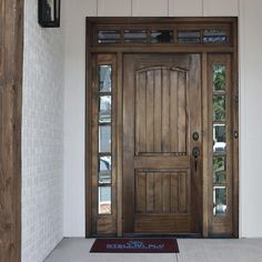 a wooden door with glass on the side of a house