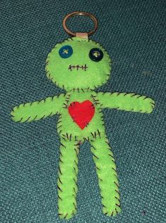 a green stuffed animal with a red heart on it's chest