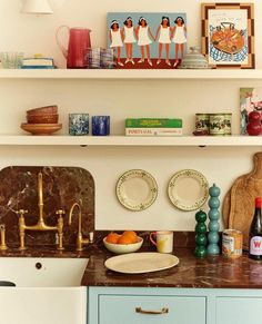 the shelves above the kitchen sink are filled with plates, bowls, and other items