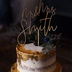 a white and gold wedding cake with the words ms & m's smith on top