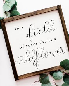 a sign that says in a field of roses she is a wildflower on it