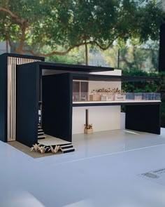 a model of a house is shown in the middle of a white table with black furniture