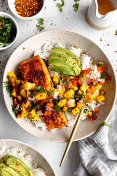 a bowl filled with rice and vegetables next to bowls of other food on the table