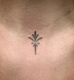 a small cross tattoo on the chest