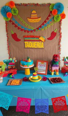 a table topped with lots of colorful desserts next to a sign that says taqueria