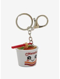 a cup with noodles and chopsticks in it is being held by a pair of scissors