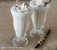 two glasses filled with whipped cream on top of a table