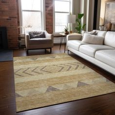 a living room filled with furniture and a large rug on top of a hard wood floor