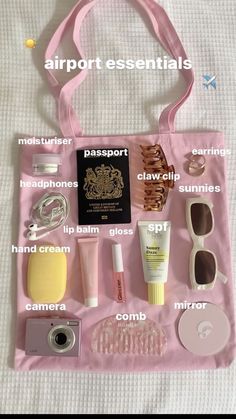 the contents of a pink bag sitting on top of a white bed next to a passport