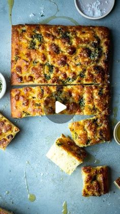 a pizza with cheese and broccoli on it is cut into slices, ready to be served