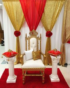 a white chair sitting on top of a red rug next to two gold and white chairs