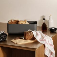 a loaf of bread sitting on top of a wooden table next to a cutting board