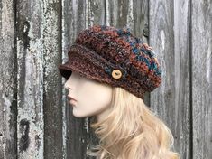 "Style: Chunky newsboy hat. It features a sturdy brim and a strap and handmade wooden buttons. Color: This sample hat is shown in Chocolate Peacock, shades from brown to rust and teal blue. Note: The coloration of these hats come out a little different every time, due to the striped nature of the yarn. If you would like photos of the exact hat that I make for you, feel free to ask, I will be happy to provide them. Sizes: One size fits 20\" to 23\" (50.5 cm to 58 cm) head size. Fiber Content: 100 Crochet Newsboy Hat, Cap Crochet, Bonnet Au Crochet, Crochet Hat For Women, Baker Boy Hat, Cable Hat, Pixie Hat, Bonnet Crochet, Handmade Knitwear