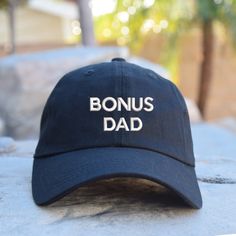 a hat that says dad vibes sitting on top of a stone slab in front of a tree