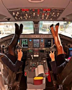 two people sitting in the cockpit of an airplane with their feet on the controls panel