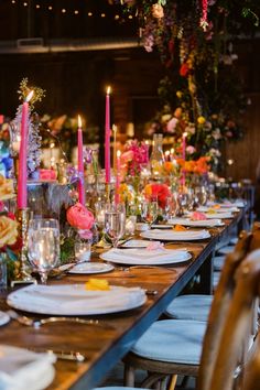 a long table is set with plates and candles