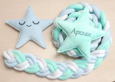 a blue and white braided wreath with a star shaped pillow on the front, and a personalized plush star in the middle