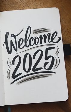 an open notebook with the words welcome 2055 written in black ink on top of it