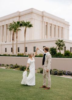 a bride and groom standing in front of a building