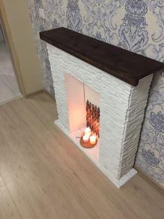 a fireplace with two lit candles in it