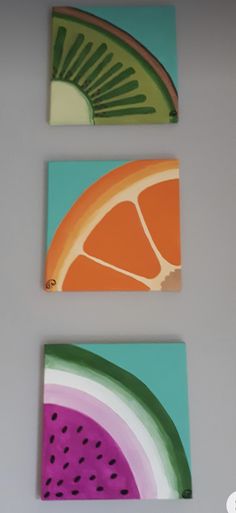 three pieces of fruit painted on canvases in different colors and shapes, each with a slice of grapefruit