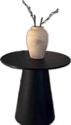 a white vase sitting on top of a black table