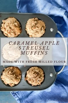 some muffins that are in a pan on a blue cloth with the words caramel apple streusel muffins made with fresh milled flour