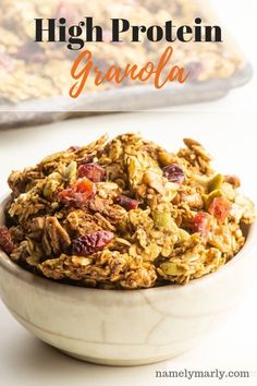 a bowl filled with granola on top of a white table next to a bag of granola