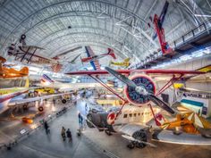 an airplane museum with many airplanes hanging from the ceiling