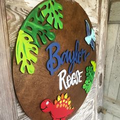 a wooden sign that says bayler's rescue with dinosaurs and leaves on it