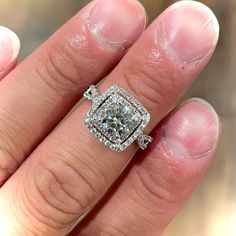 a woman's hand with a diamond ring on top of her finger and an engagement band