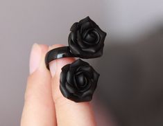 Double Floral ring with two matt black roses . Material of roses- polymer clay. Each petal made by hand. Adjustable base ring in black color about 6-8.5 us/ 16.5-18.5 mm/ 53-59 eur Base of ring is metal Size of flower about 18*18mm/ 0.7 inch DOUBLE RING WITH 2 MATT BLACK ROSES AND STAINLESS STEEL BASE - https://www.etsy.com/listing/957711501 DOUBLE RING WITH 2  BLACK PEARL ROSES AND STAINLESS STEEL BASE - https://www.etsy.com/listing/938930722 BLACK ROSE RING-  https://www.etsy.com/listing/633504133/black-rose-ring-silver-base-ring-polymer?ref=shop_home_active_4&pro=1      Black flowers set jewellery - https://www.etsy.com/listing/740056189/black-flowers-set-jewellery-polymer-clay?ref=shop_home_active_1       Black orchids necklace - https://www.etsy.com/listing/498453721/black-orchids-nec Elegant Black Flower Ring For Wedding, Black Flower Shaped Rings For Gift, Black Clay Ring, Adjustable Black Flower Jewelry, Black Flower-shaped Rings For Gifts, Black Rose Ring, Fimo Ring, Mens Black Ring, Rose Choker