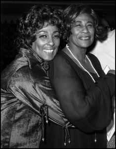 two women standing next to each other smiling