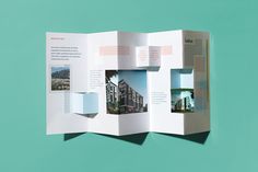 an open brochure with images of buildings on the front and back pages in it