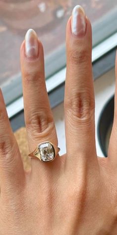 a woman's hand with a ring on it and a diamond in the middle